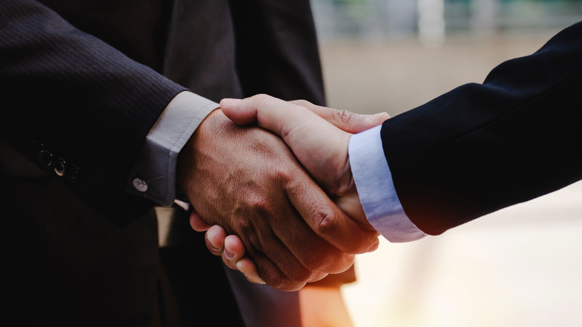 close up of business man in suit shaking hands after finishing up a business meeting