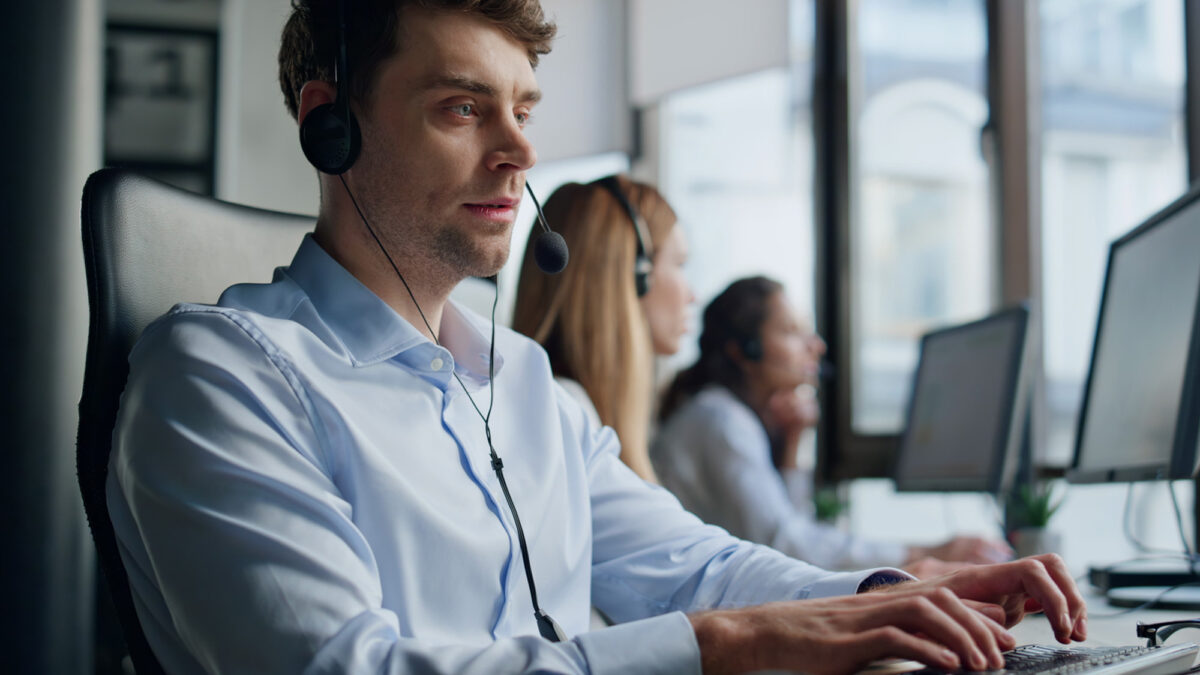 Hotline agent work computer in office. Professional support representative man