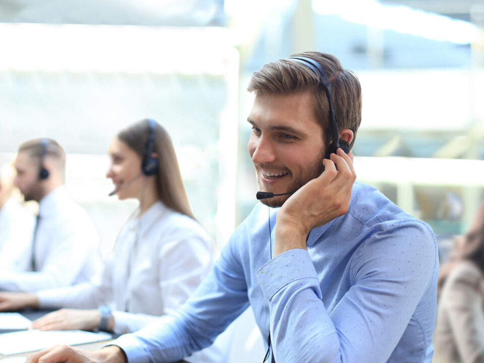 Portrait of call center worker accompanied by his team